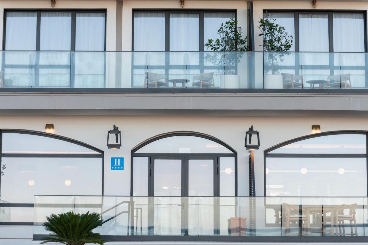 - Edificio con ventanas y balcón con mesas en Hiru Uhinak, en Deba