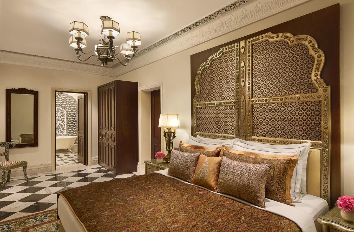 a bedroom with a large bed with a large headboard at Jai Mahal Palace in Jaipur