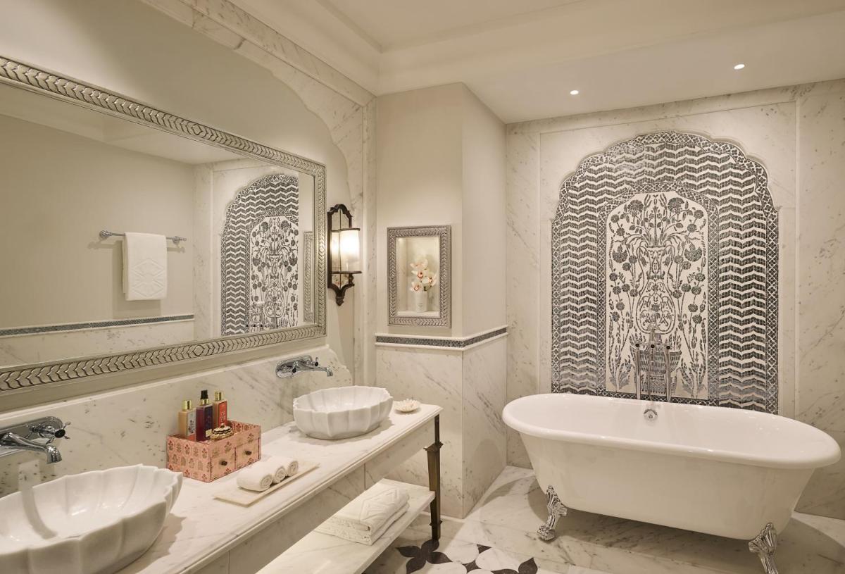 a bathroom with a tub and a sink and a mirror at Jai Mahal Palace in Jaipur