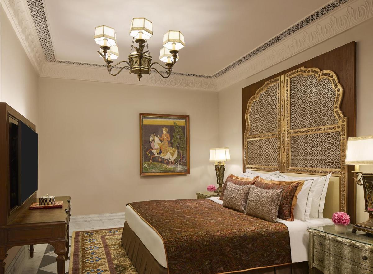a bedroom with a large bed and a television at Jai Mahal Palace in Jaipur