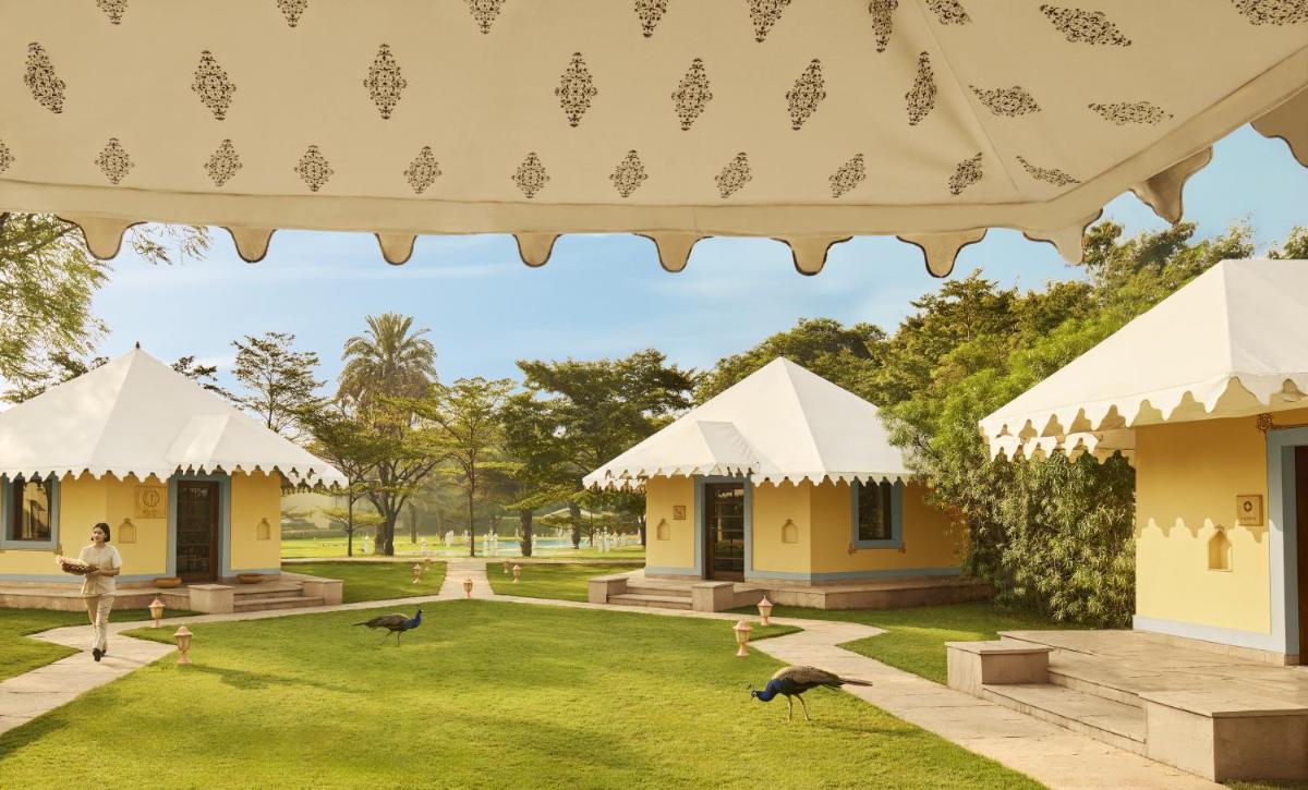 a view of the grounds of a resort with birds in the grass at Jai Mahal Palace in Jaipur