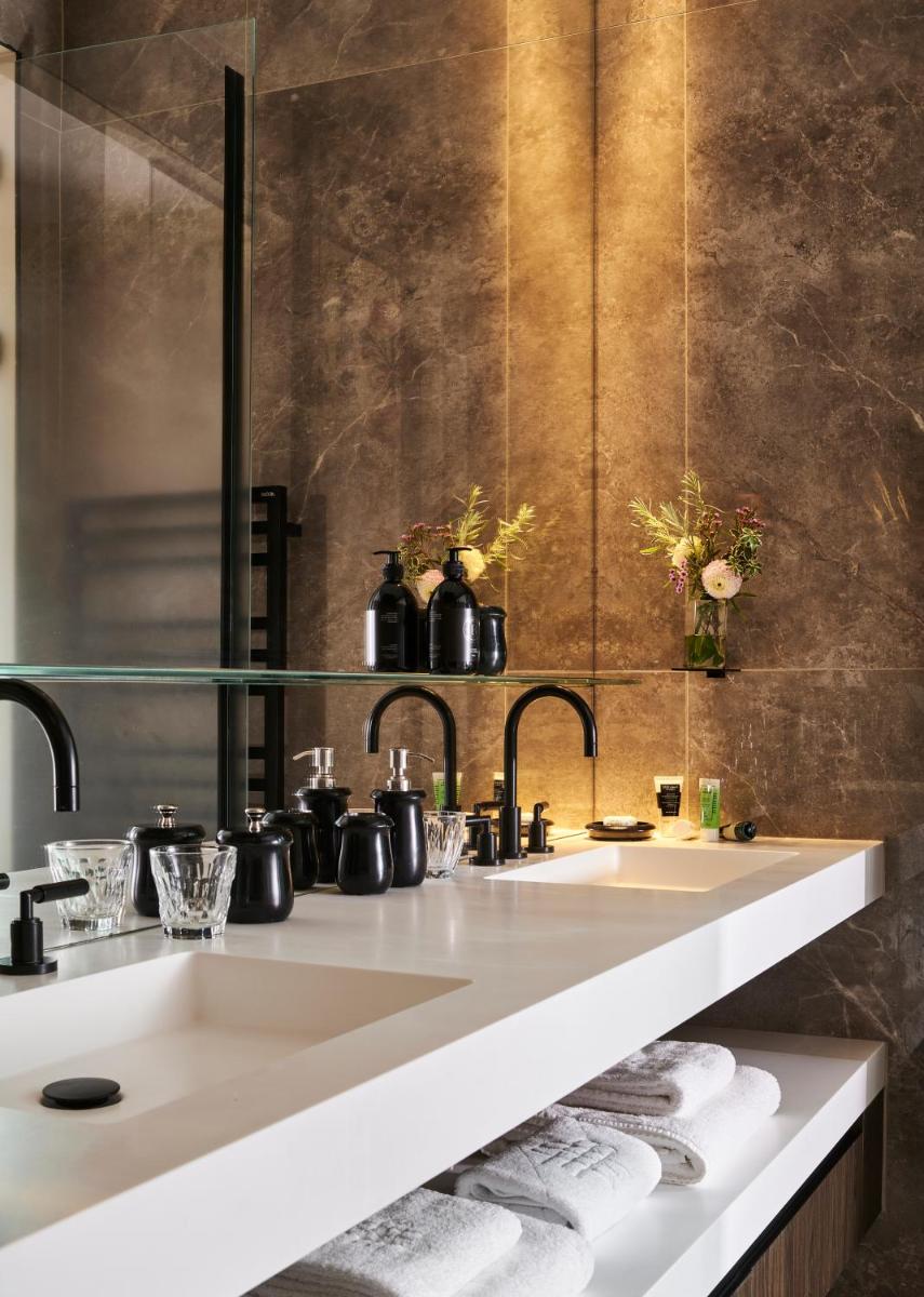 une salle de bain avec un lavabo et un comptoir avec des serviettes dans l'établissement Maison Boissière BARNES Residences, à Paris