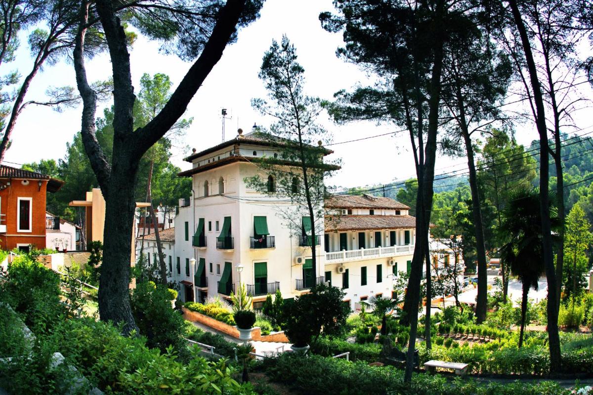 un edificio en medio de un bosque de árboles en Balneario de Cofrentes, en Cofrentes
