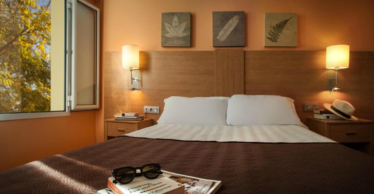 Un dormitorio con una cama con un libro y vasos encima. en Balneario de Cofrentes, en Cofrentes 17 fotos más
