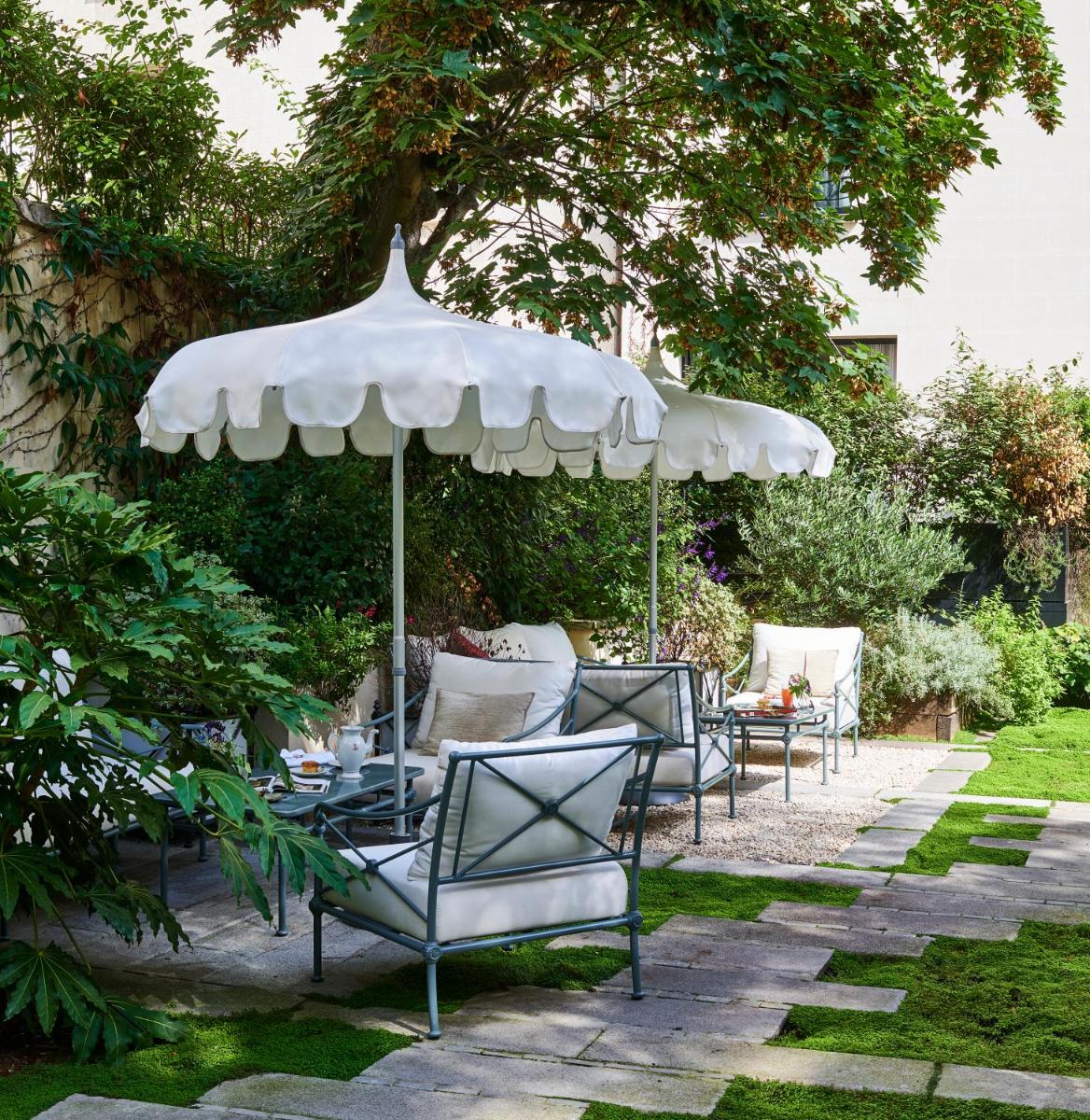 un groupe de chaises assises sous un parasol dans l'établissement Maison Boissière BARNES Residences, à Paris