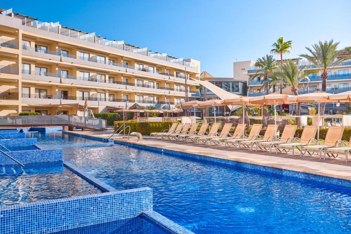 Una piscina con sillas y un hotel. en Zafiro Palmanova, en Palmanova 80 fotos más
