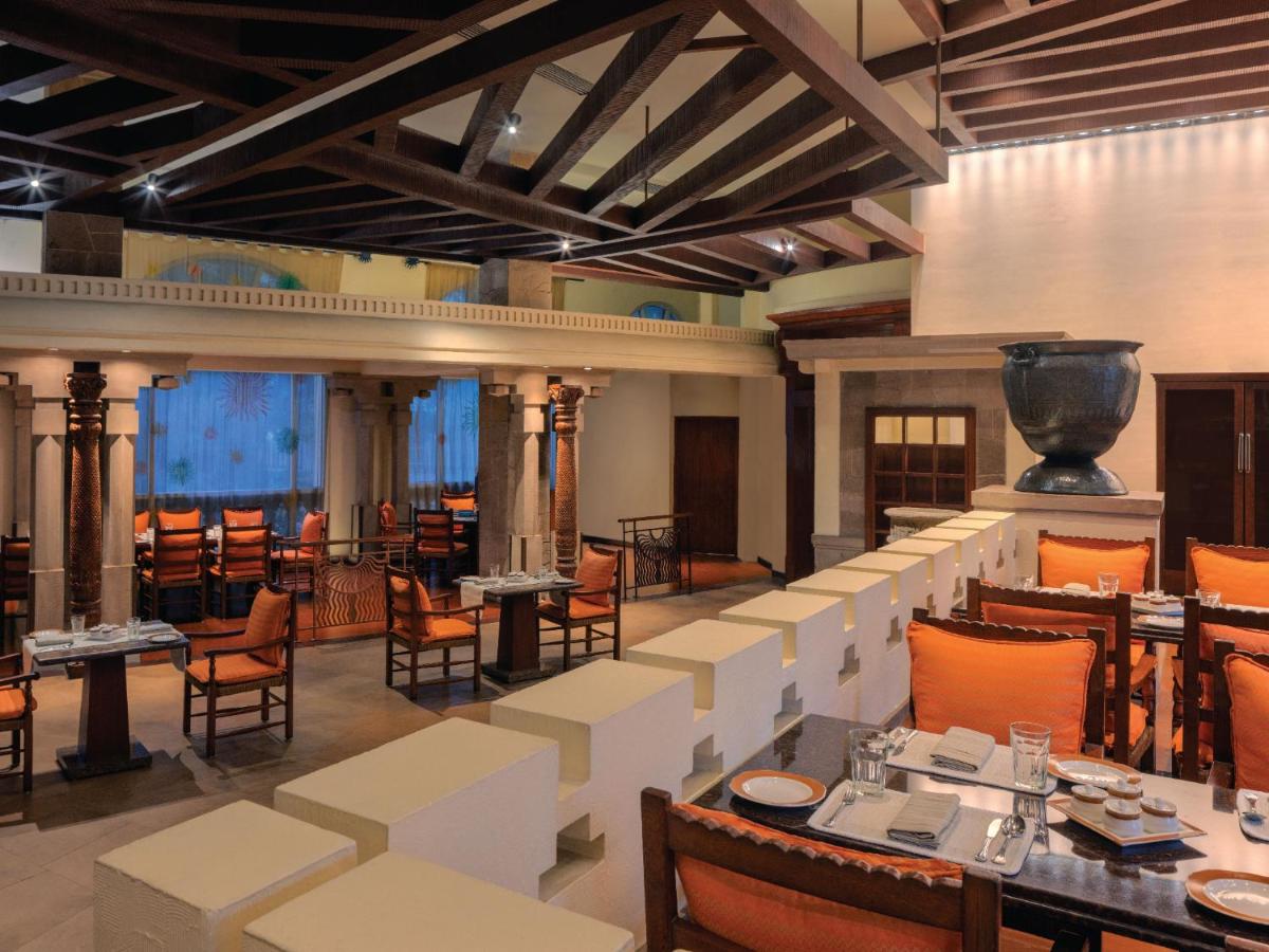 a dining room with tables and chairs and a large room at ITC Grand Central, a Luxury Collection Hotel, Mumbai in Mumbai