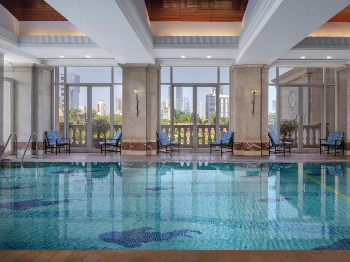 a swimming pool in a hotel with chairs and windows at ITC Grand Central, a Luxury Collection Hotel, Mumbai in Mumbai