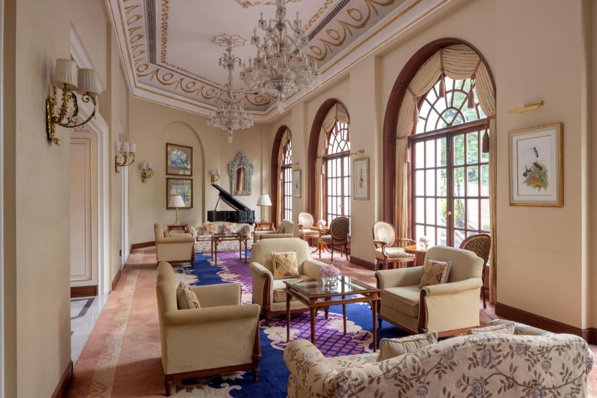 a large living room with chairs and a chandelier at ITC Windsor, a Luxury Collection Hotel, Bengaluru in Bengaluru a large living room with chairs and a chandelier at ITC Windsor, a Luxury Collection Hotel, Bengaluru in Bengaluru