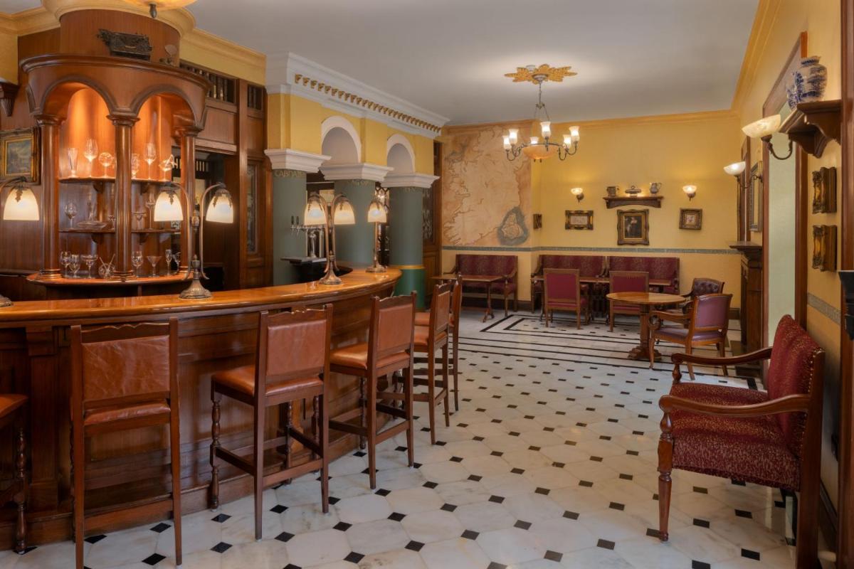 a bar in a restaurant with chairs and tables at ITC Windsor, a Luxury Collection Hotel, Bengaluru in Bengaluru a bar in a restaurant with chairs and tables at ITC Windsor, a Luxury Collection Hotel, Bengaluru in Bengaluru