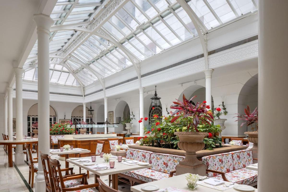 a restaurant with tables and chairs and a glass ceiling at ITC Windsor, a Luxury Collection Hotel, Bengaluru in Bengaluru a restaurant with tables and chairs and a glass ceiling at ITC Windsor, a Luxury Collection Hotel, Bengaluru in Bengaluru
