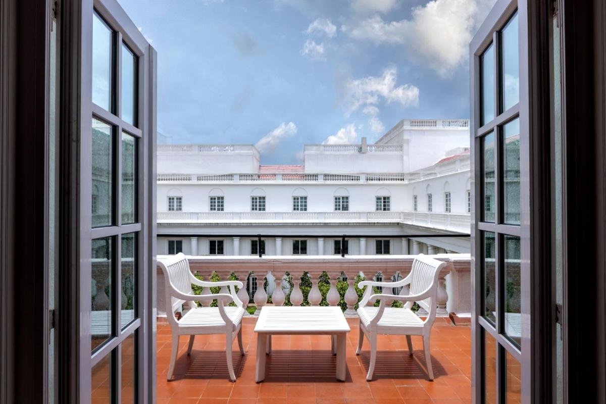 a balcony with a table and two chairs and a building at ITC Windsor, a Luxury Collection Hotel, Bengaluru in Bengaluru a balcony with a table and two chairs and a building at ITC Windsor, a Luxury Collection Hotel, Bengaluru in Bengaluru