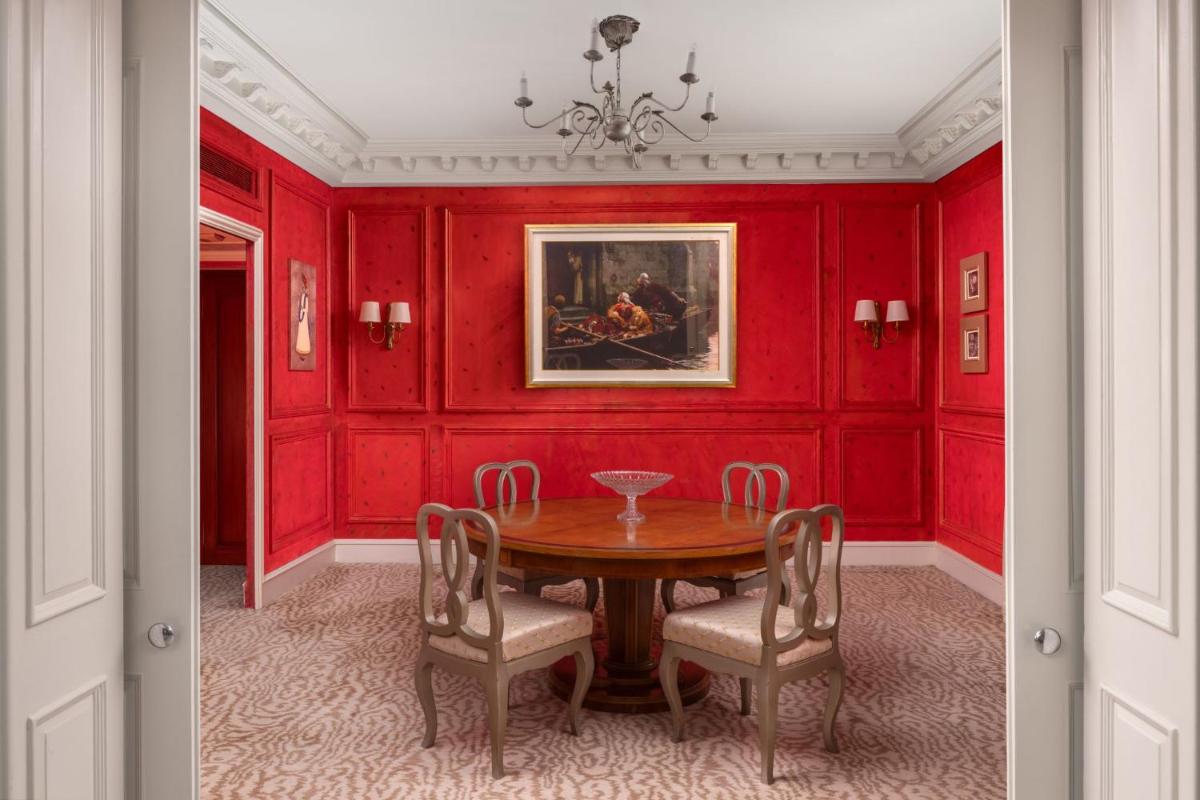 a dining room with red walls and a table and chairs at ITC Windsor, a Luxury Collection Hotel, Bengaluru in Bengaluru a dining room with red walls and a table and chairs at ITC Windsor, a Luxury Collection Hotel, Bengaluru in Bengaluru