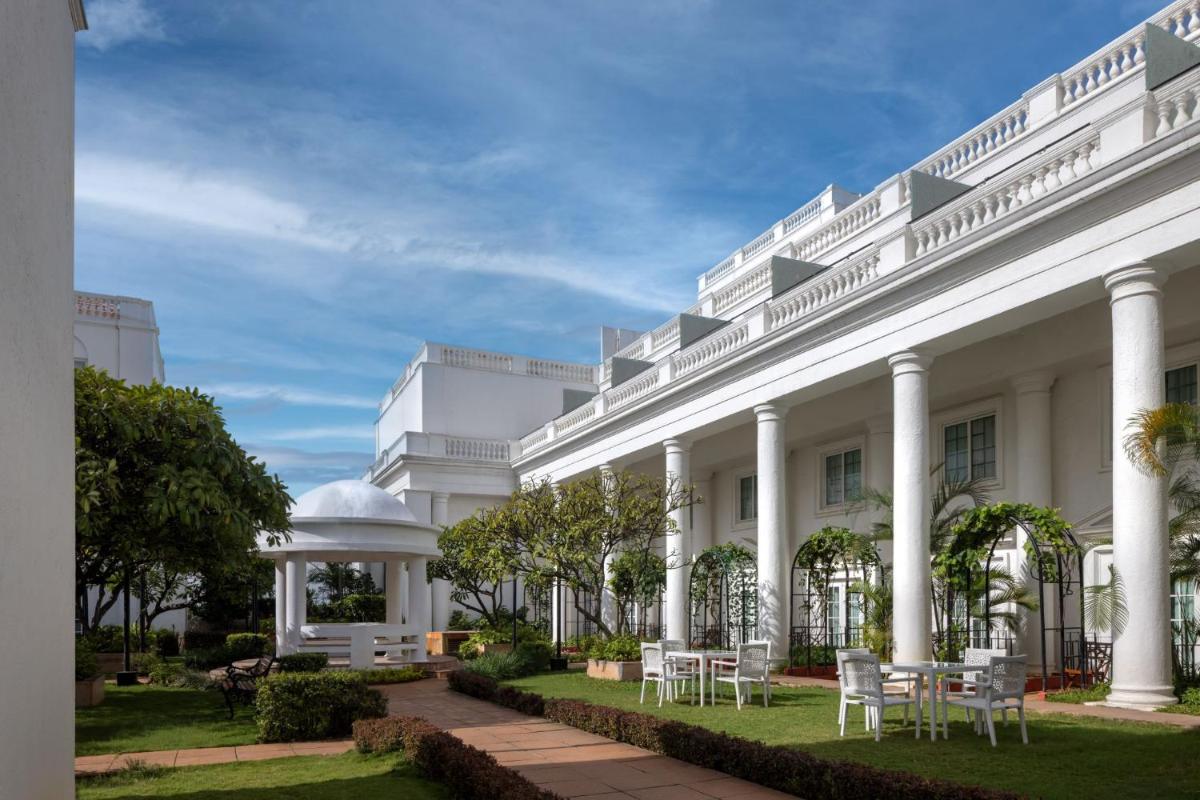 a white building with chairs and a gazebo at ITC Windsor, a Luxury Collection Hotel, Bengaluru in Bengaluru a white building with chairs and a gazebo at ITC Windsor, a Luxury Collection Hotel, Bengaluru in Bengaluru