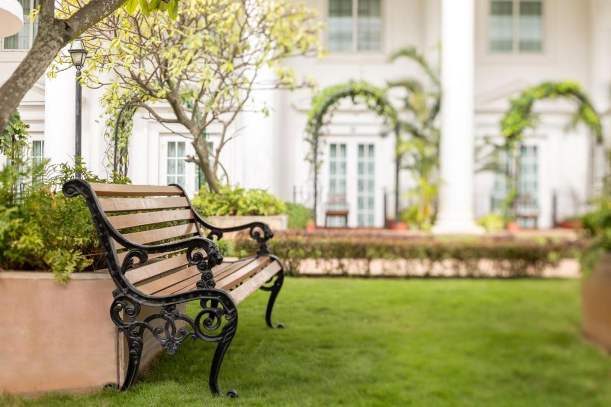 a park bench sitting in front of a house at ITC Windsor, a Luxury Collection Hotel, Bengaluru in Bengaluru a park bench sitting in front of a house at ITC Windsor, a Luxury Collection Hotel, Bengaluru in Bengaluru