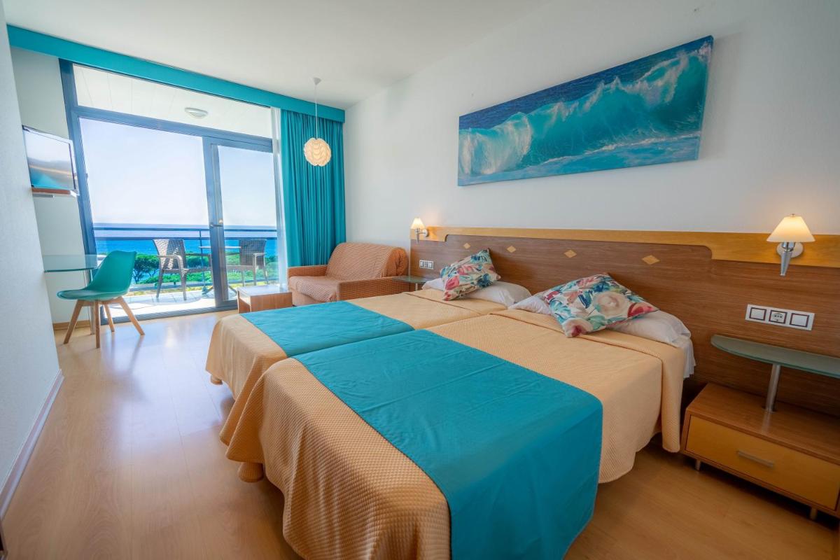 Una habitación de hotel con dos camas y vista al mar. en Hotel Blaucel, en Blanes