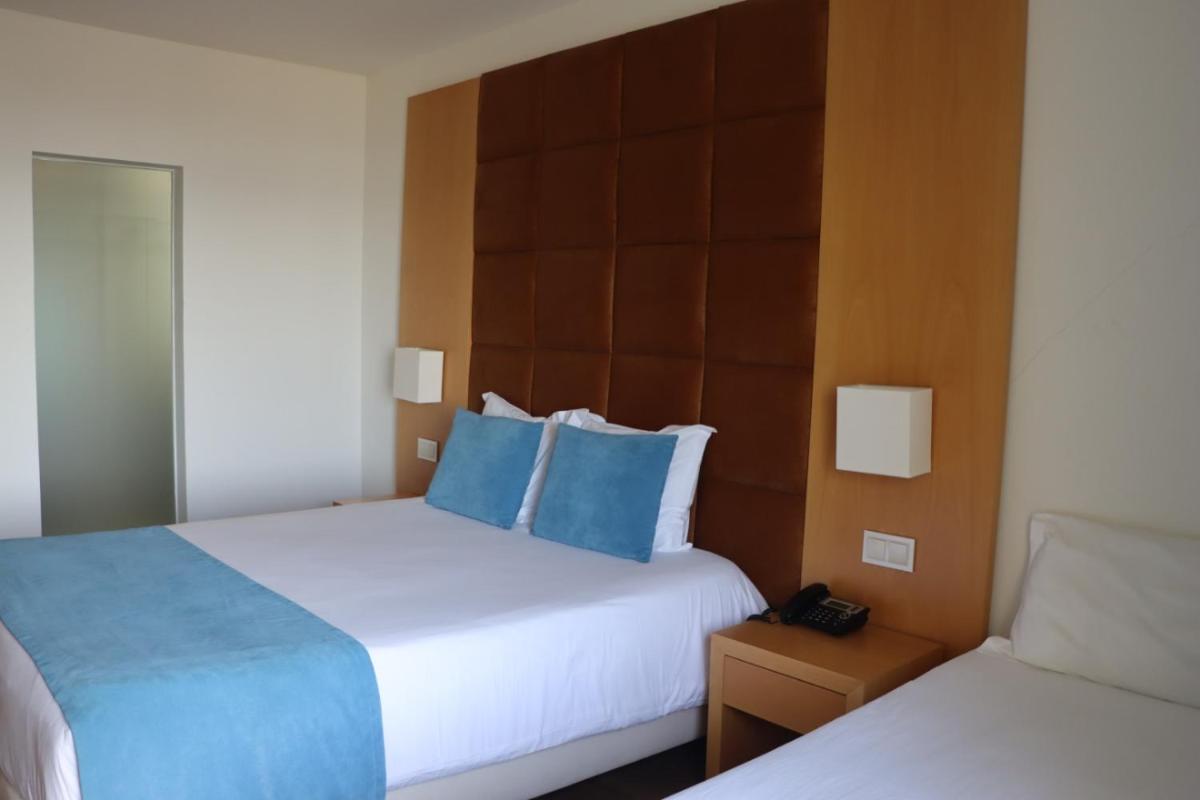 Uma cama ou camas num quarto em Hotel Atlantida Sol