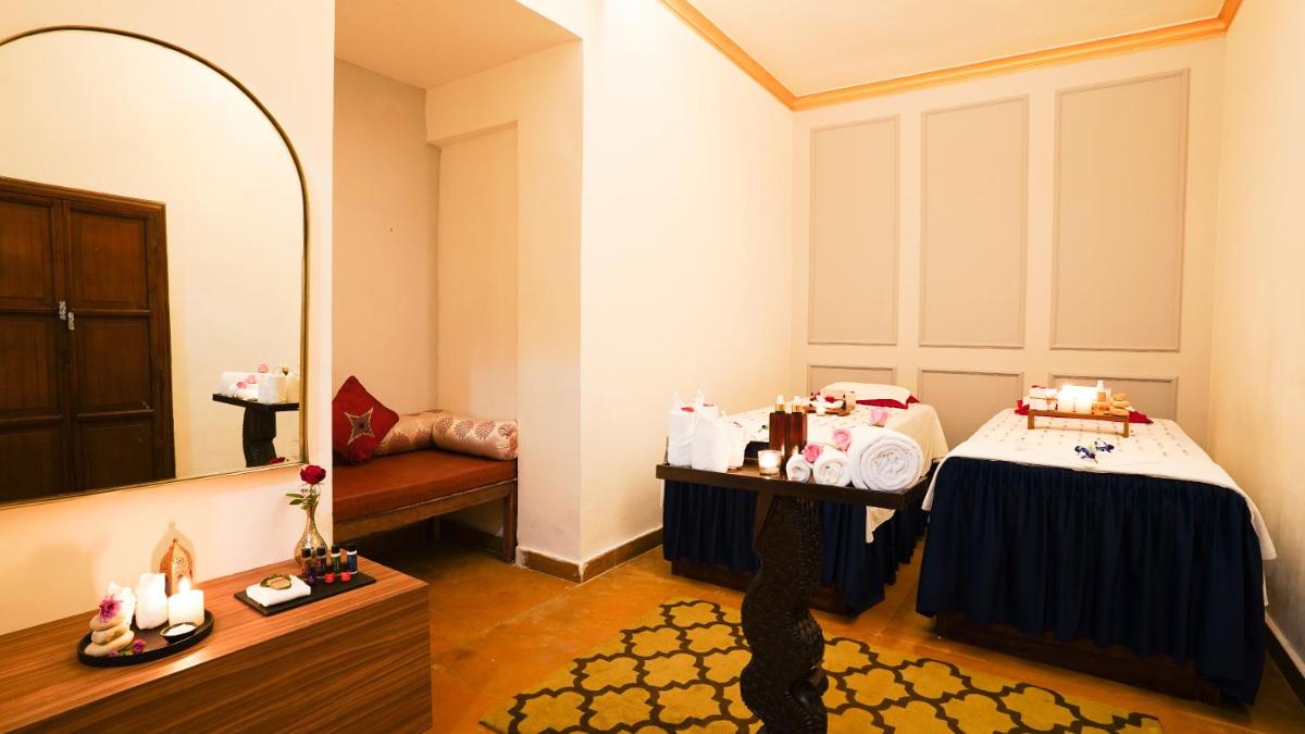 a dressing room with a bed and a mirror at Saraca Hotel Lucknow in Lucknow