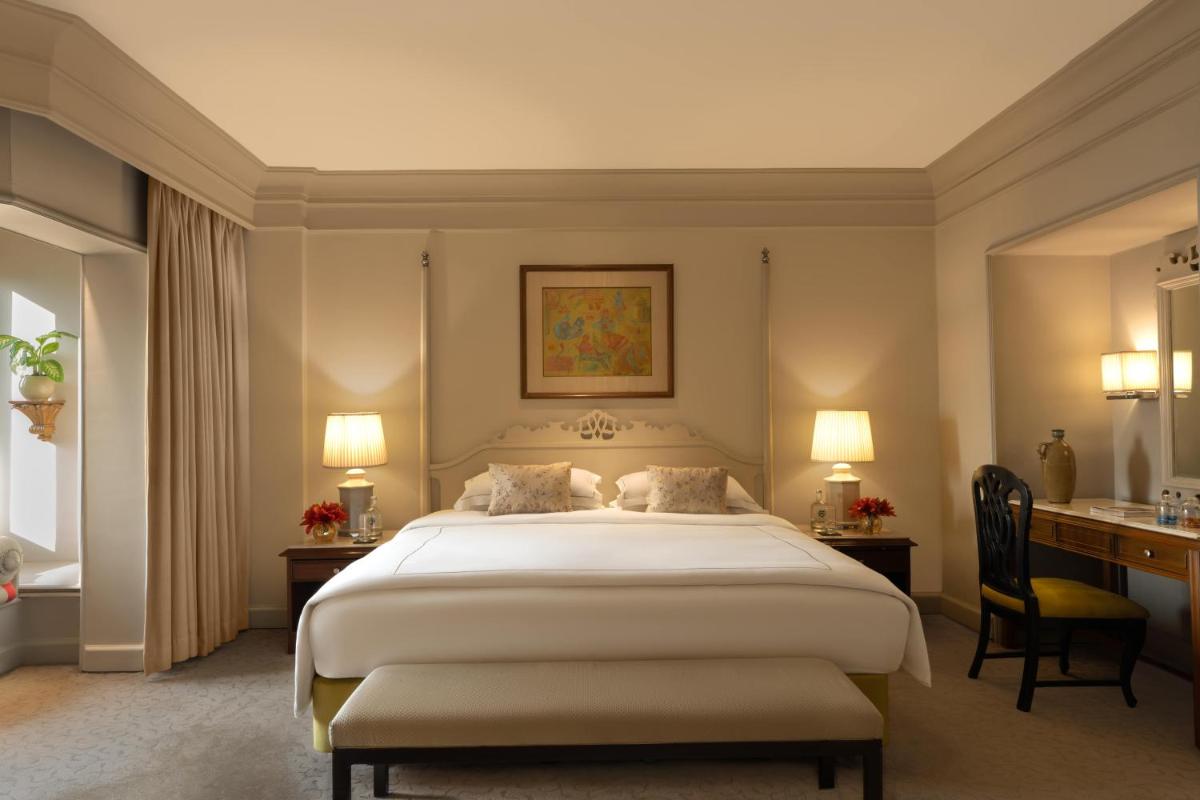a bedroom with a large white bed and a desk at Taj Bengal in Kolkata