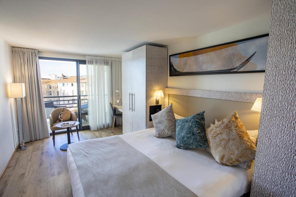 une chambre d'hôtel avec un lit et un balcon dans l'établissement Eden Hotel & Spa, à Cannes