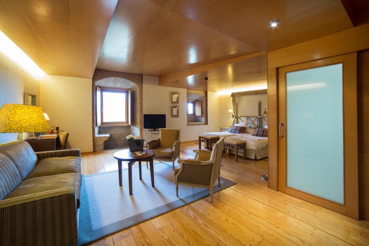 una sala de estar con un sofá y una mesa en Parador de Santo Estevo, en Santo Estevo de Rivas de Sil