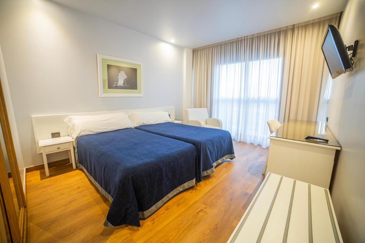 Cama o camas de una habitación en Hotel Auditorio Santiago & Spa