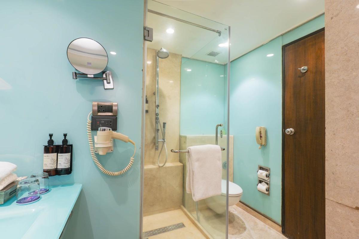 a bathroom with a shower and a sink at Hotel Royal Orchid Bangalore in Bengaluru
