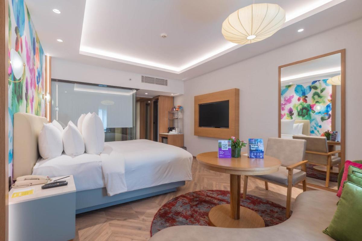 a hotel room with a bed and a table at Hotel Royal Orchid Bangalore in Bengaluru