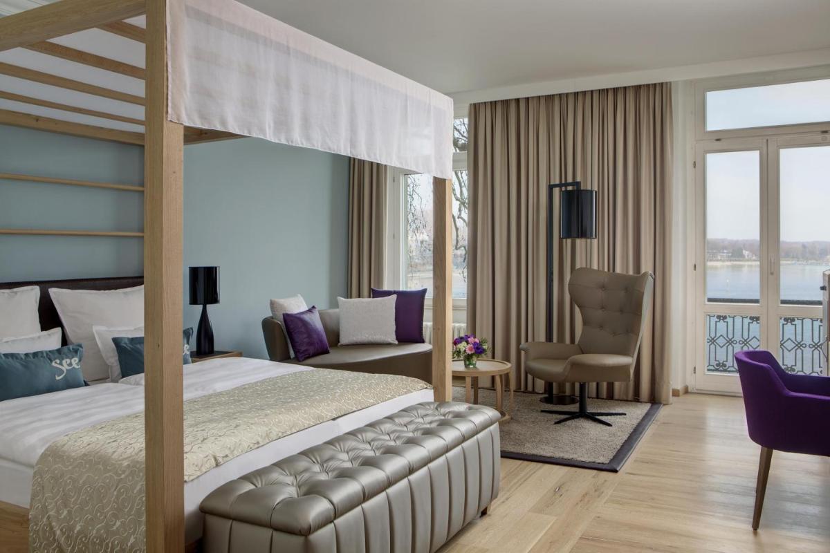 ein Schlafzimmer mit einem Bett, einem Schreibtisch und einem Stuhl in der Unterkunft Steigenberger Inselhotel in Konstanz