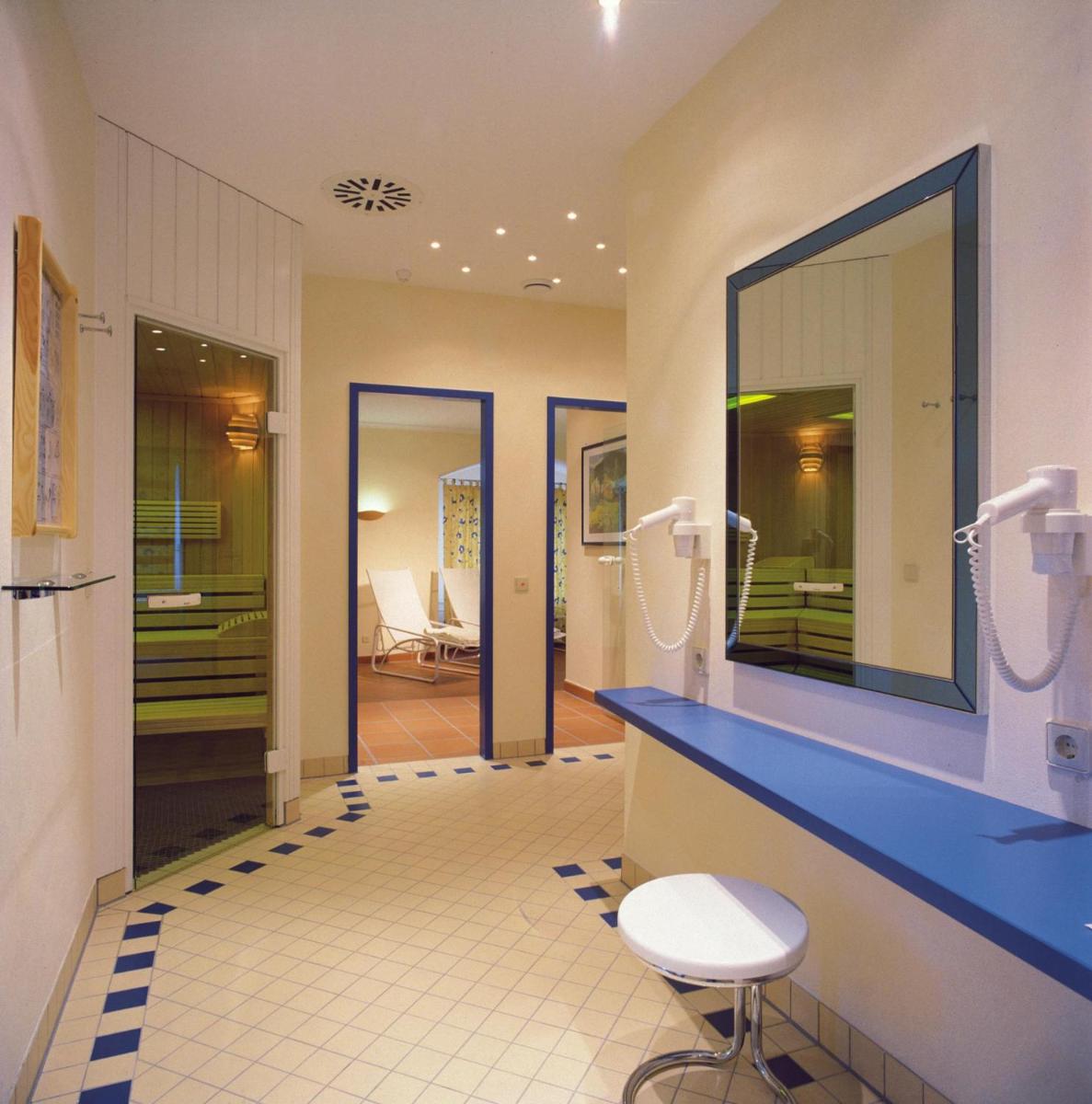 ein Badezimmer mit einer blauen Theke und einem Spiegel in der Unterkunft Steigenberger Inselhotel in Konstanz