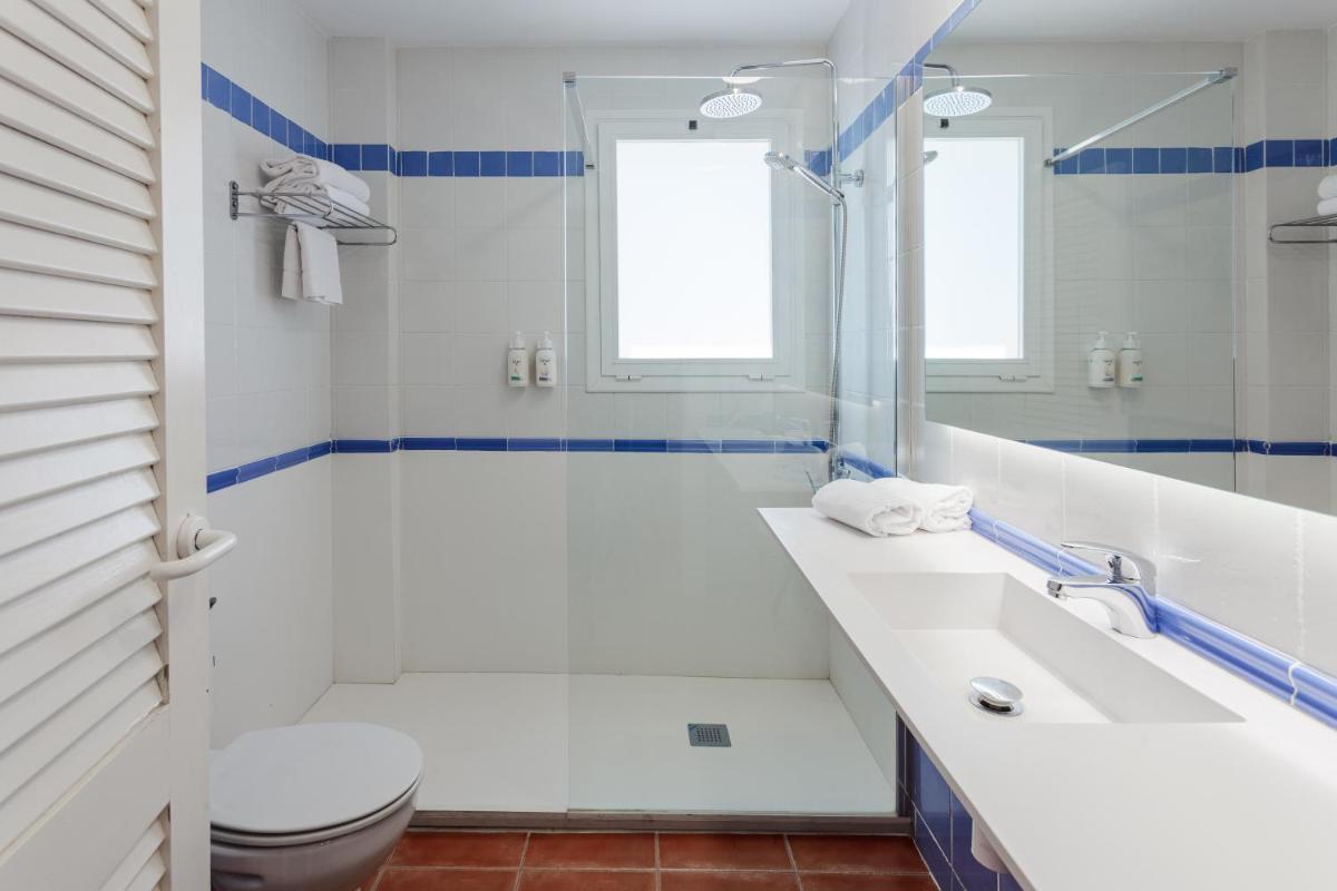 Un baño blanco con bañera y inodoro. en DWO Les Palmeres, en Calella 30 fotos más