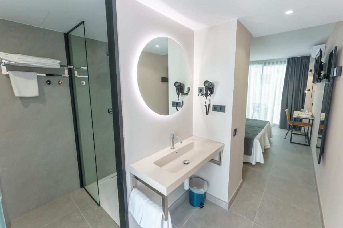 Un baño con lavabo, ducha y espejo. en DWO Les Palmeres, en Calella