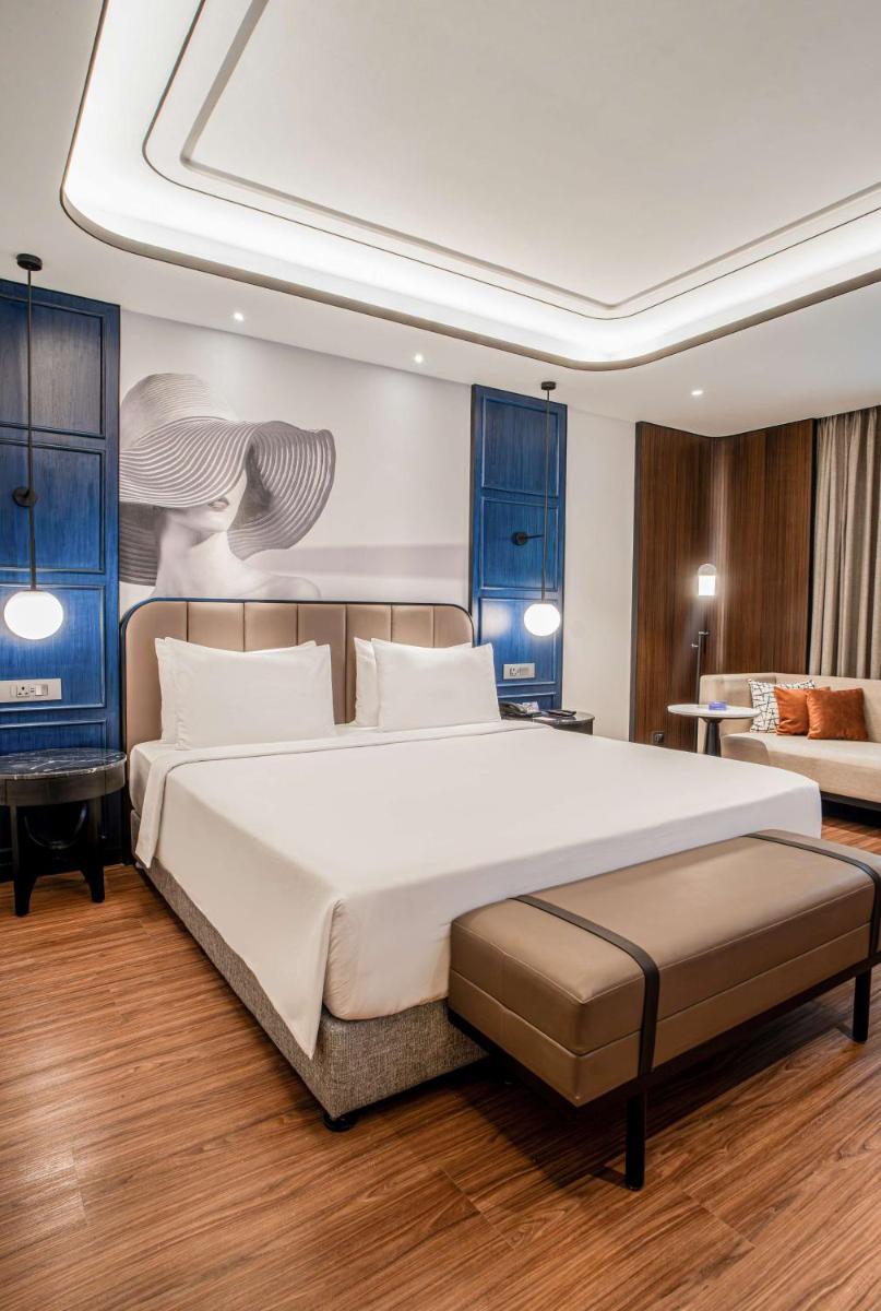 a bedroom with a large white bed and a couch at Radisson Blu Hotel Ahmedabad in Ahmedabad