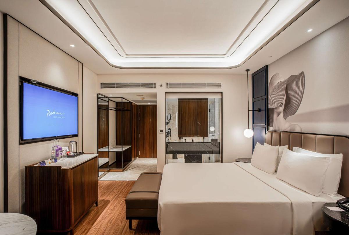a hotel room with a bed and a television at Radisson Blu Hotel Ahmedabad in Ahmedabad