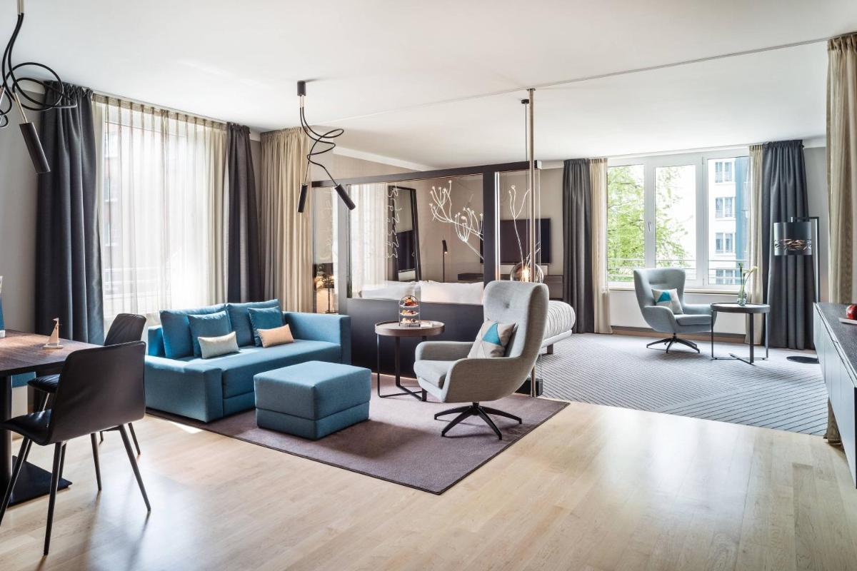 ein Wohnzimmer mit einem blauen Sofa und Stühlen in der Unterkunft Le Méridien Hamburg in Hamburg + 37 Fotos