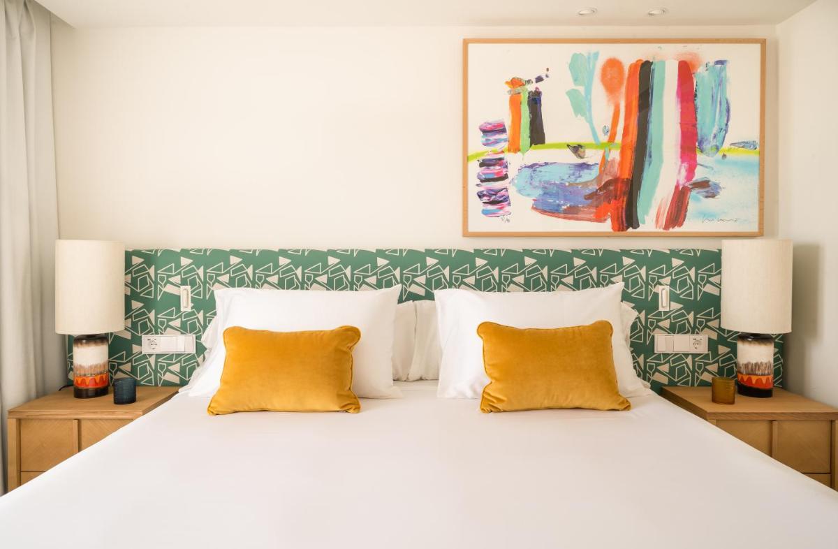 Un dormitorio con una gran cama blanca con almohadas amarillas. en Kimpton Los Monteros Marbella by IHG, en Marbella