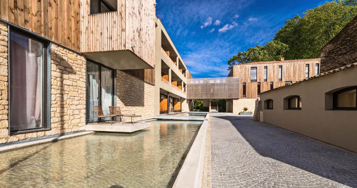 une vue extérieure d'un canal entre deux bâtiments dans l'établissement Hôtel du Golf, à Mallemort