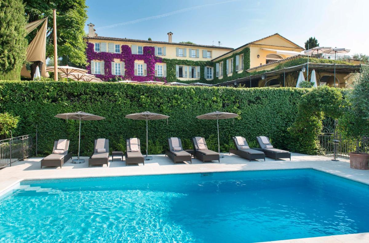 un groupe de chaises et de parasols à côté d'une piscine dans l'établissement Bastide Saint Antoine - Relais & Châteaux, à Grasse