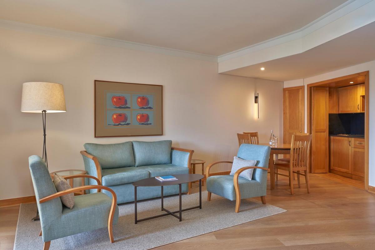 uma sala de estar com um sofá, cadeiras e uma mesa em Hotel Porto Mare - PortoBay no Funchal