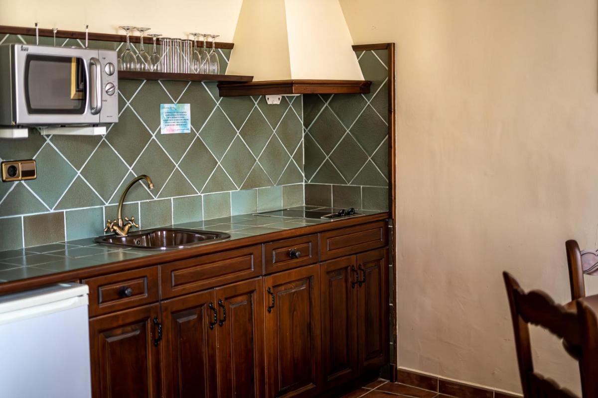 una cocina con fregadero y microondas en Hotel SPA Don Iñigo de Aragón, en Las Cuevas de Cañart 10 fotos más