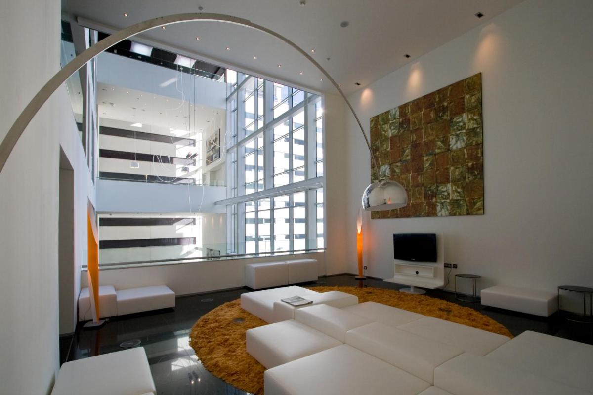 Una sala de estar con un sofá blanco y una ventana grande. en Axor Barajas, en Madrid