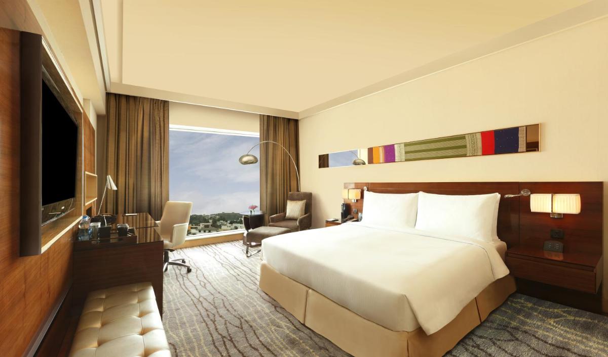 a hotel room with a bed and a television at Hilton Chennai in Chennai