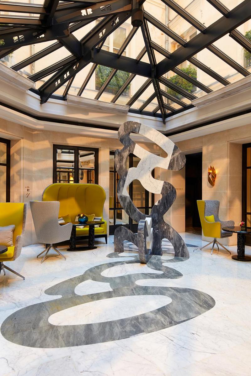 un hall d'entrée avec une sculpture au milieu d'une pièce dans l'établissement Le Burgundy Paris, à Paris