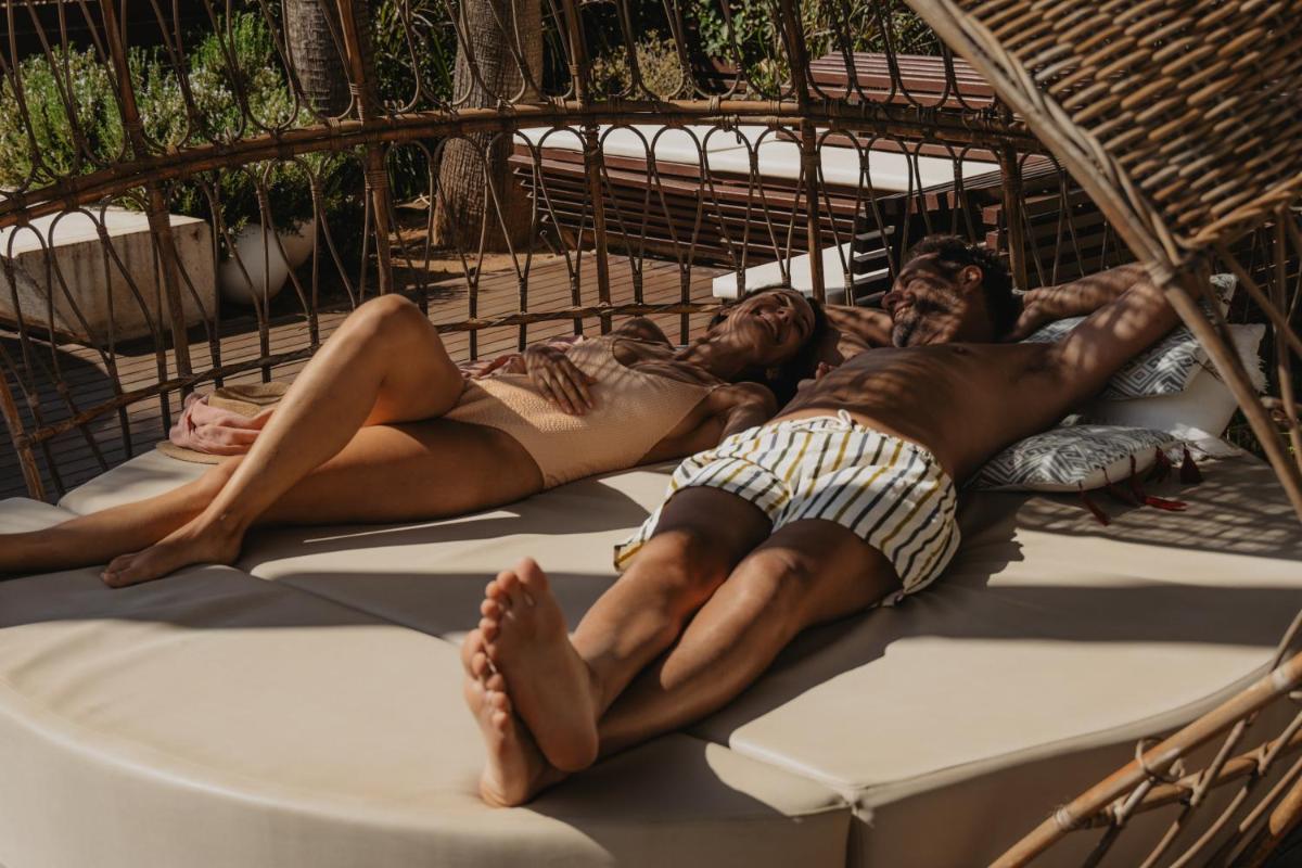 dos hombres y una mujer tumbados en una hamaca en Iberostar Waves Bahía de Palma - Adults Only, en Playa de Palma