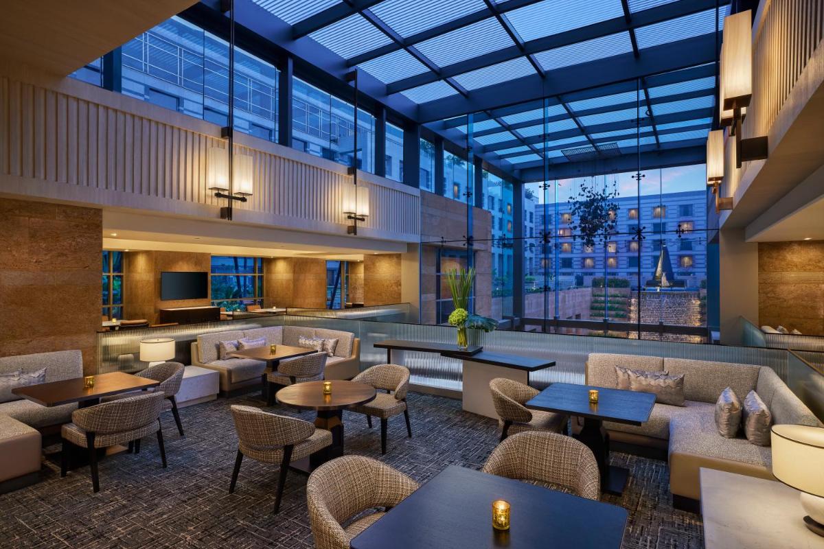 a restaurant with tables and chairs and windows at Grand Hyatt Mumbai Hotel and Residences in Mumbai