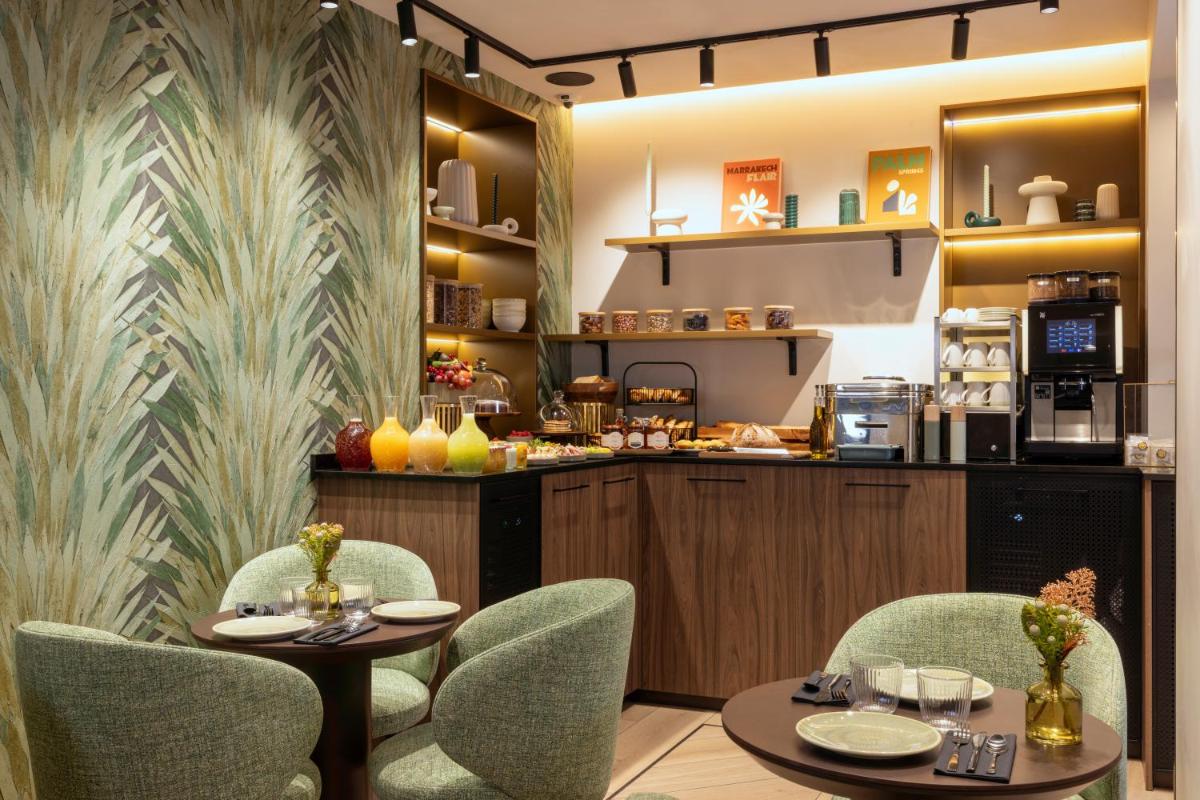 un restaurant avec deux tables et des chaises ainsi qu'un comptoir dans l'établissement Hôtel Théorème, à Paris