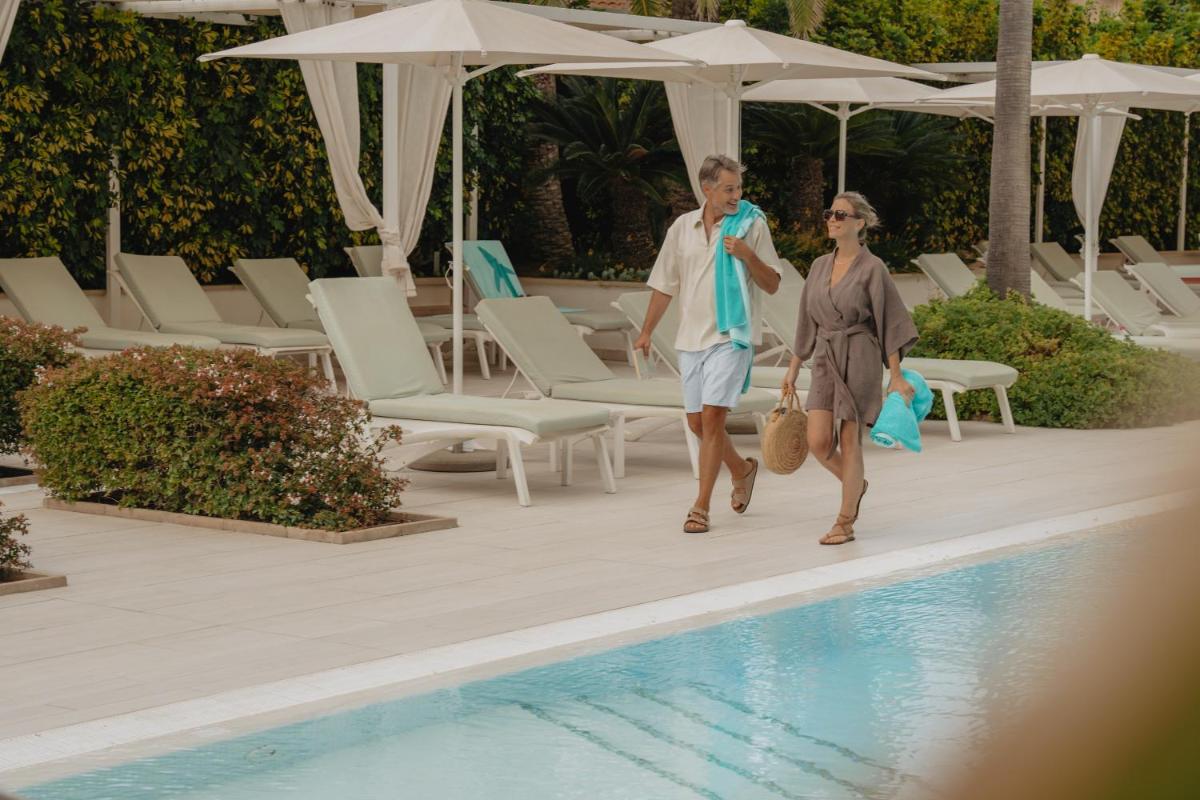 un hombre y una mujer caminando por una piscina en Iberostar Selection Playa de Palma, en Playa de Palma