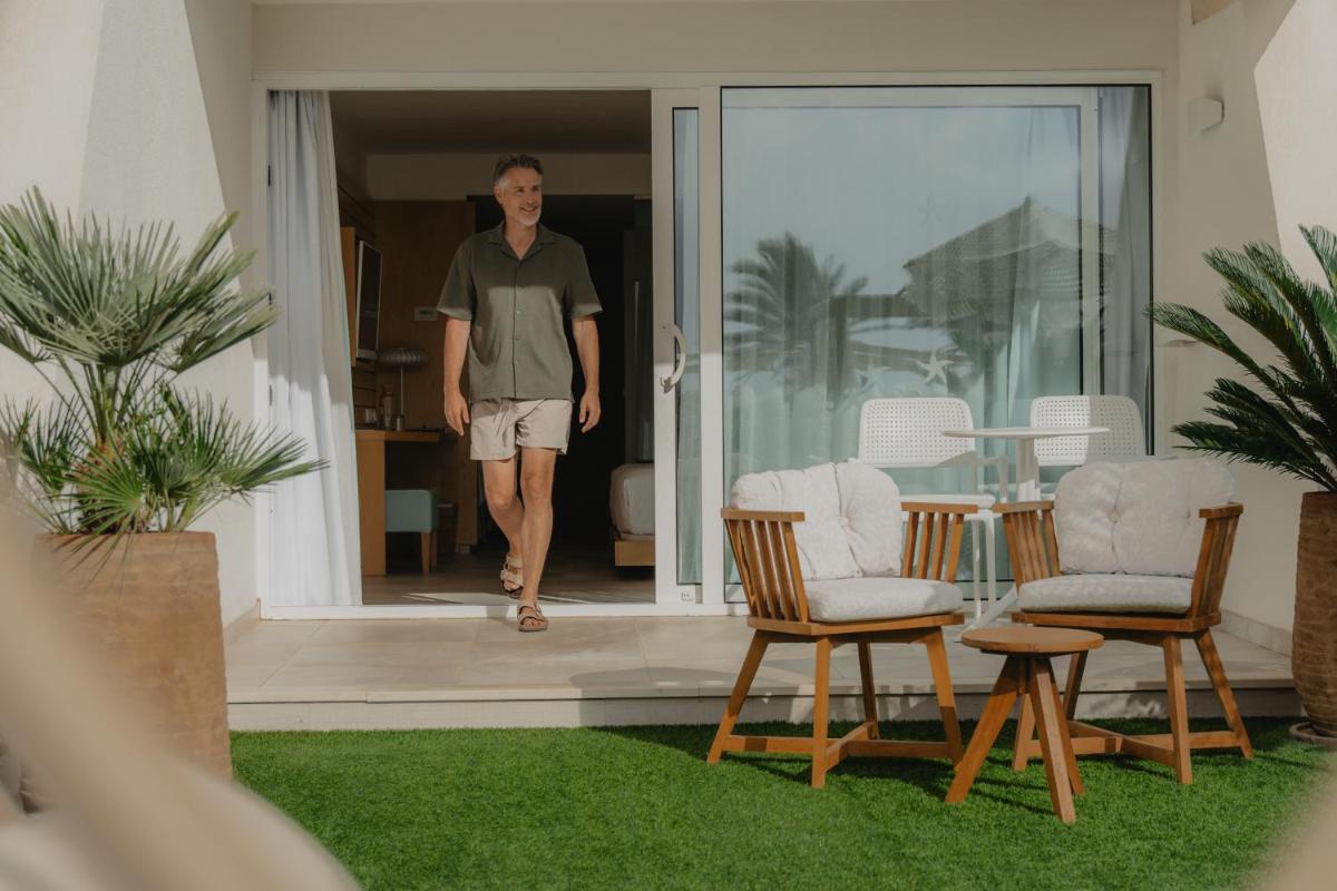un hombre entrando en una casa con dos sillas en Iberostar Selection Playa de Palma, en Playa de Palma