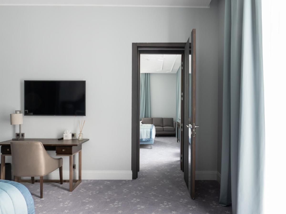 Cette chambre comprend un bureau, une télévision et une porte. dans l'établissement Villa Genesis, à Menton