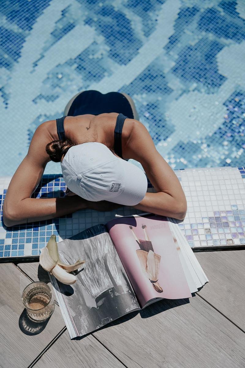 una mujer tirada en el suelo junto a una piscina en The Donna Portals, en Portals Nous